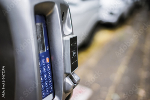 Parking machine or Parking meters with electronic payment in the city streets and a row of cars in Sydney Australia.