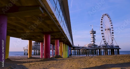 Watching the Ferris wheel turn from under the pier on the beach in Scheveningen, Netherlands photo