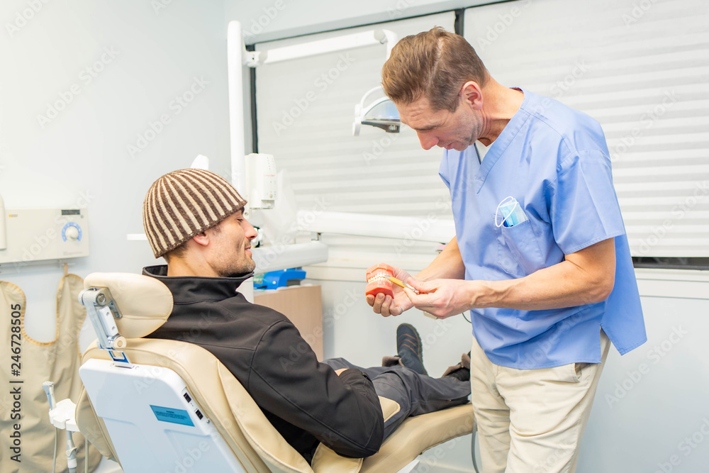 Obraz premium Dentist explains to patient on teeth mockup