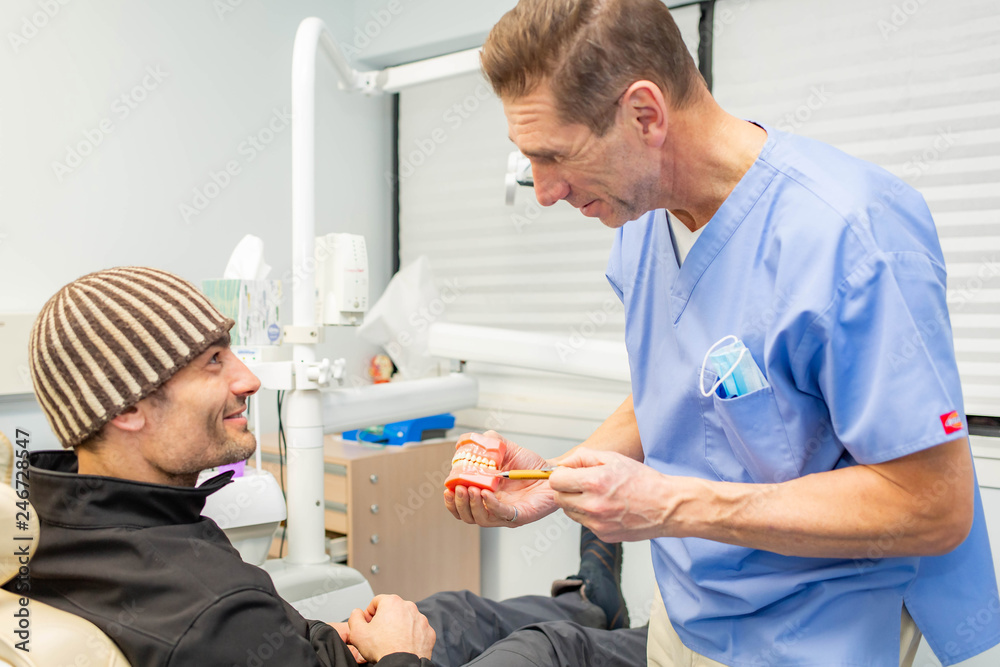 Fototapeta premium Dentist explains to patient on teeth mockup