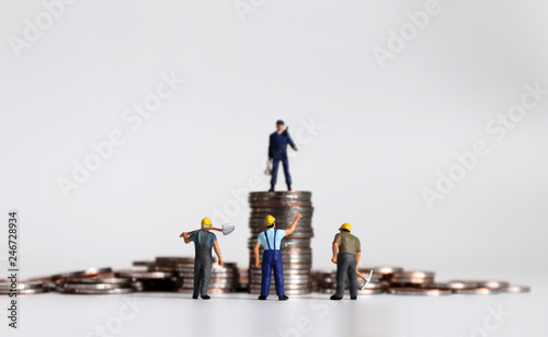 Miniature people and coins. photo