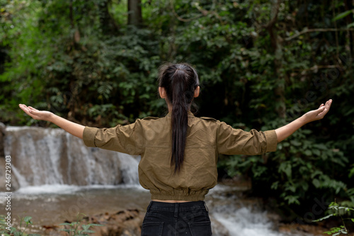 Female tourists are happy and refreshed at the waterfall.