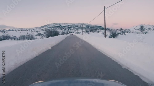 Driving on a snowy mountain road. Returning from Ziria ski center. Sunset colors in the horizon. photo