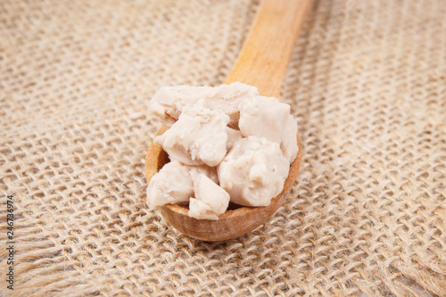 Fresh crumbled yeast on spoon for baking different dough or bread
