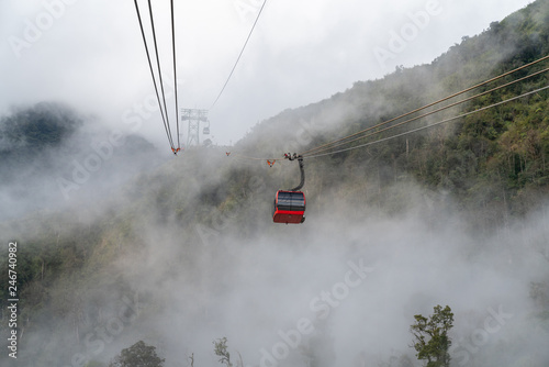 The cable car to mountain top with low clouds and mountain view