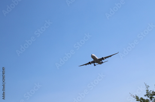 Scenery of airplane flying in clear blue sky of sunny day. The best mean of transportation in modern world. 