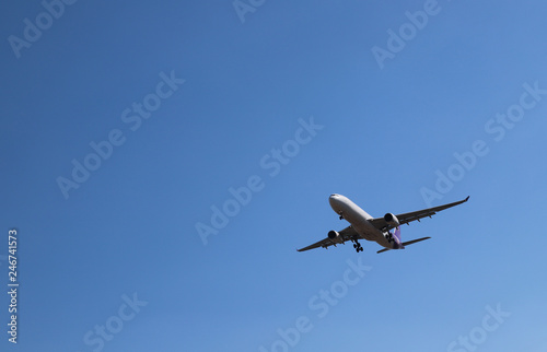 Scenery of airplane flying  in clear blue sky of sunny day. The best way of transportation in modern world. 