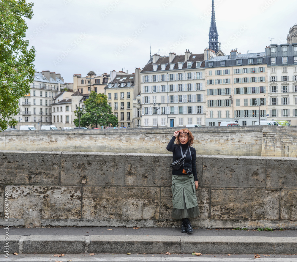 A woman standing on riverbank of Seine