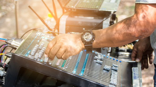 The hands of professional technicians control the audio mixer.
