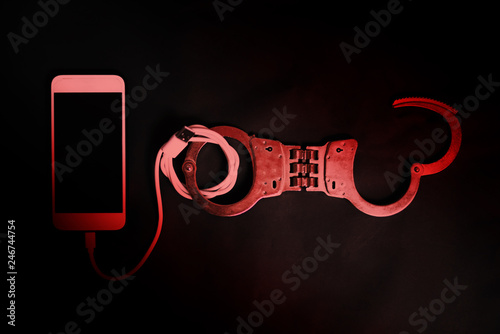 Smart phone with handcuff in the dark, Smart phone addiction concept photo