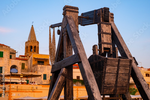 Alghero, Sardinia, Italy - Summer sunset view of the Alghero old town quarter with historic defense walls, fortifications and catapult construction