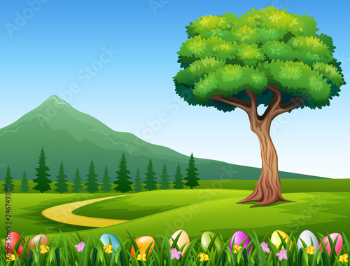 Colorful Easter eggs on green grass with beautiful landscape
