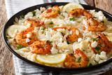 Spicy orzo pasta with grilled shrimps, feta cheese, herbs and lemon close-up on a plate. horizontal