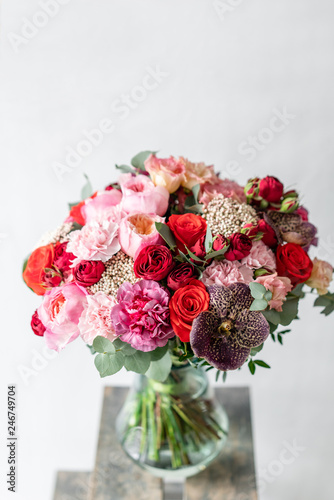 Fototapeta Naklejka Na Ścianę i Meble -  beautiful fresh cut bouquet of mixed flowers in vase on wooden table. . the work of the florist at a flower shop. Delicate Pastel tones color