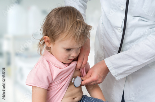 Pediatrician doctor examining a little girl by stethoscope