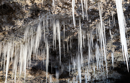 Many icicles hanging from the ceiling of the cave.