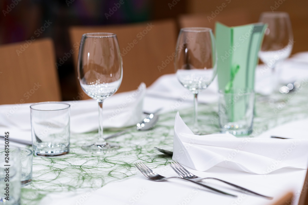 Decorated table on a gala dinner party with wine glasses and blurred out background