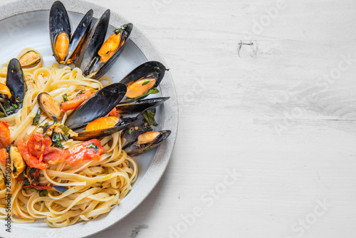 Mediterranean dish - linguine pasta with mussels on a plate. Copy space for recipe