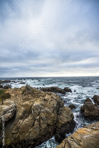 Ocean waves crashing on rocks, coastline view in California. Sand and rocks on a beach © valeragf