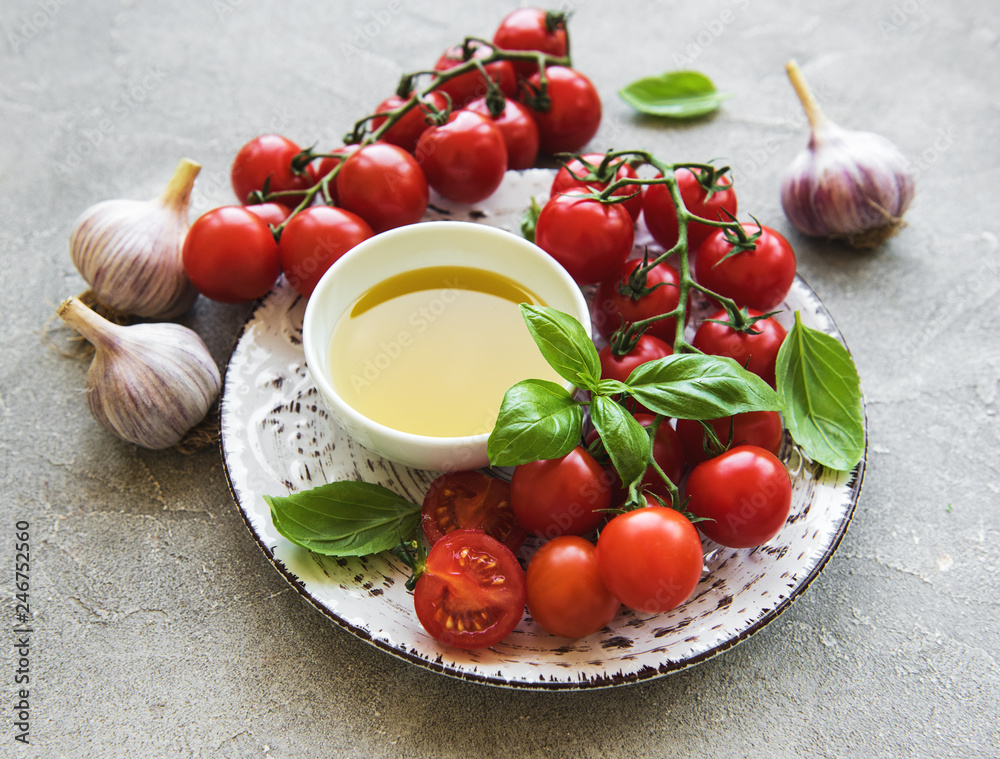 Plate with cherry tomatoes, olive oil and basil