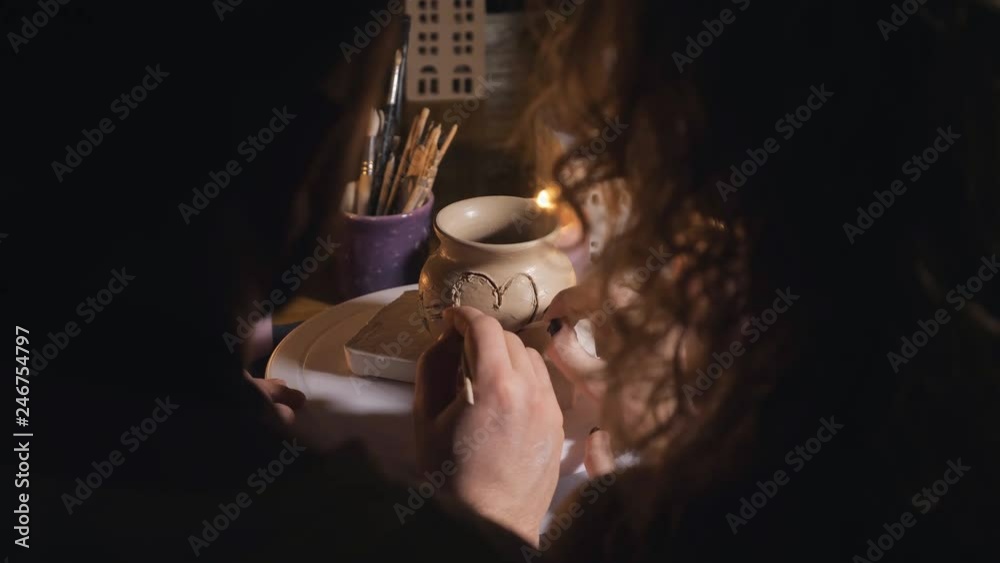 romantic couple in love working together in craft studio workshop and draw a heart on a clay pot, back view romantic couple in love working together in craft studio workshop and draw a heart on a clay pot, back view