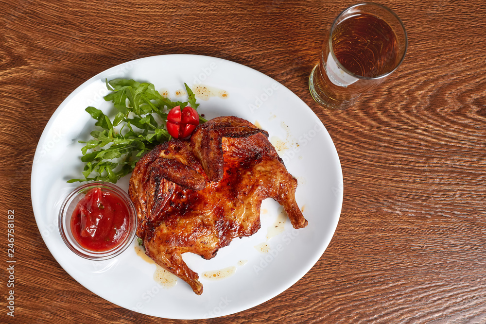 Fototapeta premium fried quail with red tomato-based sauce served with a glass of beer
