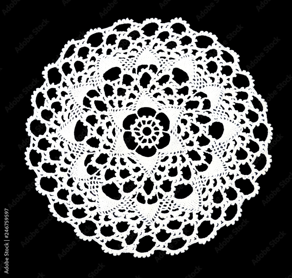 Isolated crocheted laced white doily with many picos at the egde on a black background. Round decorative cotton doily