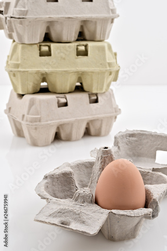 scatola porta uova vuote e con uovo su fondo bianco