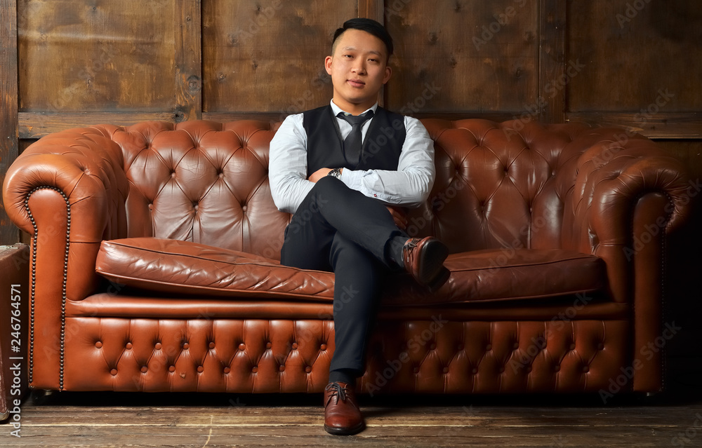 Successful man sitting on a leather couch Successful man sitting on a leather couch