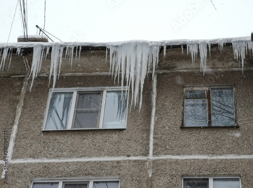 Large icicles hang on the house in winter