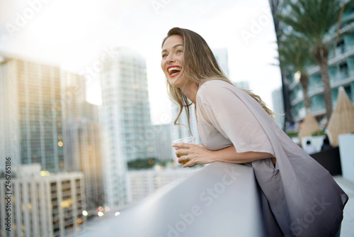 Atttractive elegant young woman having fun smiling on rooftop bar in city © goodluz