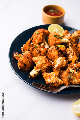 Tandoori Gobi / Roasted cauliflower Tikka is a dry dish made by roasting Cauliflowers in Oven/Tandoor. It's popular starter food from India. served with ketchup. selective focus