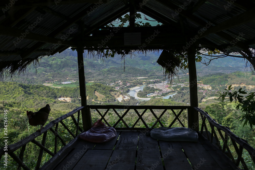 Panoramic view from a roadside bamboo hut of a green Valley covered with lush green forests and Mekong river near Luang Prabang in northern Laos