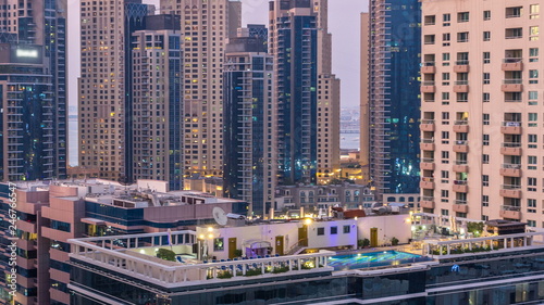 Aerial view of Dubai Marina after sunset from a vantage point day to night timelapse.