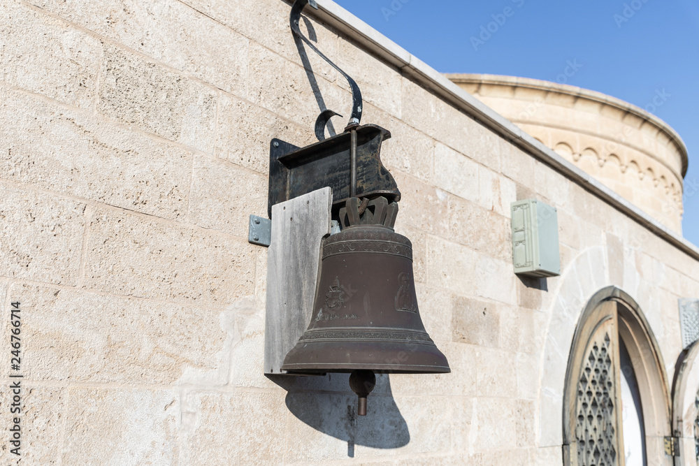 Obraz premium Copper bell hanging on the wall of the International Marian Centre in Nazareth city in Israel