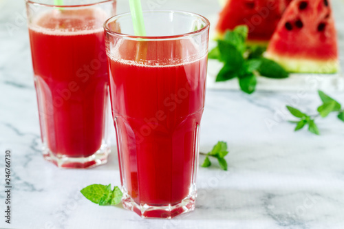 Cold watermelon lemonade with mint and lemon in glass glasses and ingredients for lemonade on a light background.