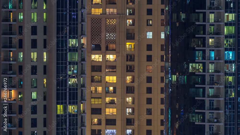 Glowing windows in multistory modern glass and metal residential building light up at night timelapse. Glowing windows in multistory modern glass and metal residential building light up at night timelapse.