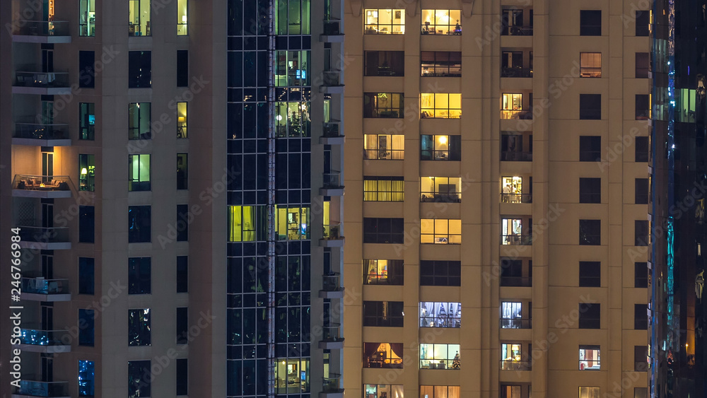 Glowing windows in multistory modern glass and metal residential building light up at night timelapse. Glowing windows in multistory modern glass and metal residential building light up at night timelapse.