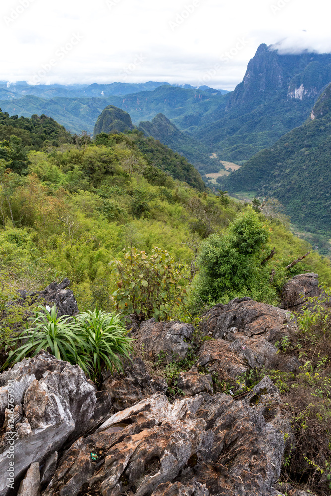 View from the top Viewpoint of Nong Khiaw - a secret village in Laos. Stunning scenery of limestone cliff valley covered with green rainforest jungle mysterious clouds. A gem of north Laos. View from the top Viewpoint of Nong Khiaw - a secret village in Laos. Stunning scenery of limestone cliff valley covered with green rainforest jungle mysterious clouds. A gem of north Laos.