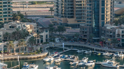 Luxury Dubai Marina canal with passing boats and promenade timelapse, Dubai, United Arab Emirates © neiezhmakov