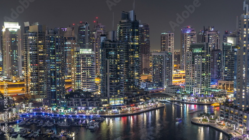 Luxury Dubai Marina canal with passing boats and promenade night timelapse  Dubai  United Arab Emirates