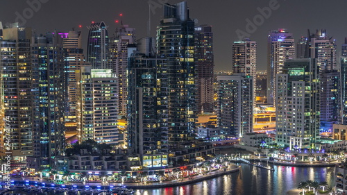 Luxury Dubai Marina canal with passing boats and promenade night timelapse, Dubai, United Arab Emirates