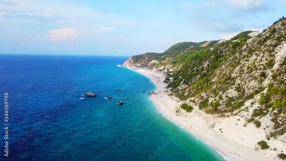 Aerial drone bird's eye view video of popular beach of Milos with turquoise clear waters and sun beds, island of Lefkada, Ionian, Greece Aerial drone bird's eye view video of popular beach of Milos with turquoise clear waters and sun beds, island of Lefkada, Ionian, Greece