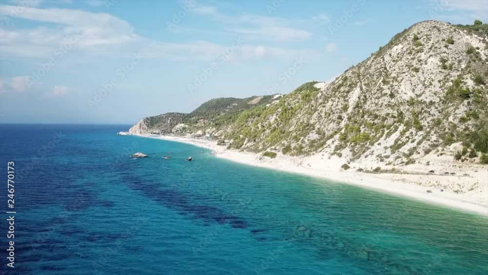 Aerial drone bird's eye view video of popular beach of Milos with turquoise clear waters and sun beds, island of Lefkada, Ionian, Greece Aerial drone bird's eye view video of popular beach of Milos with turquoise clear waters and sun beds, island of Lefkada, Ionian, Greece
