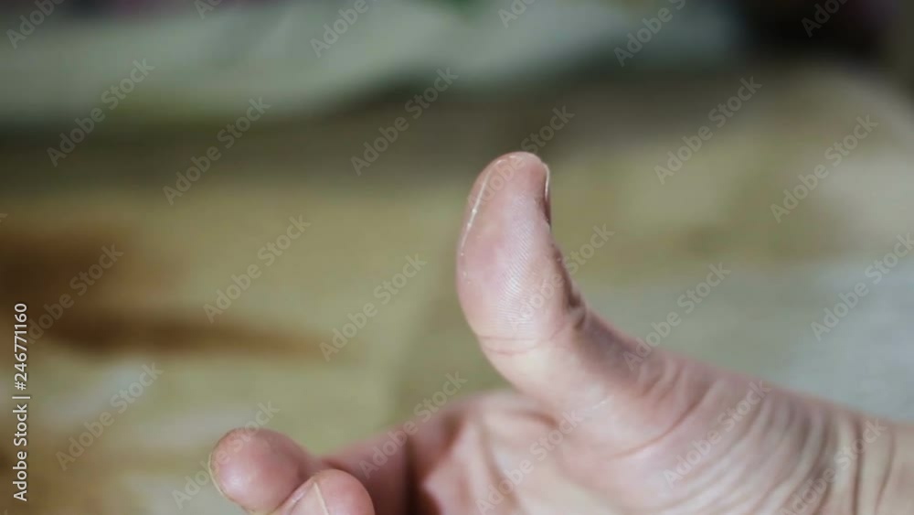 On the finger of the hand is a small transparent worm. Worm pulled from salted marine fish salmon. Real time, close-up, indoors, contains people On the finger of the hand is a small transparent worm. Worm pulled from salted marine fish salmon. Real time, close-up, indoors, contains people