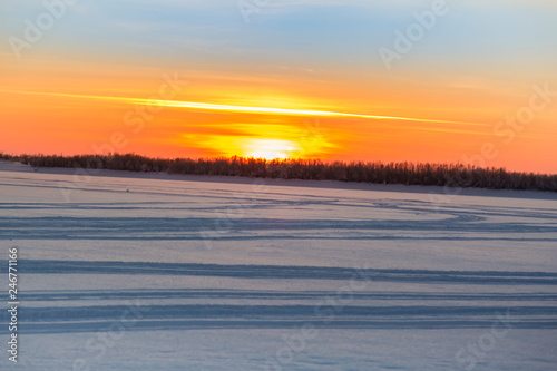 January sunset over a snow covered river