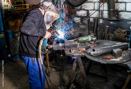 Welder soldering a piece in a factory