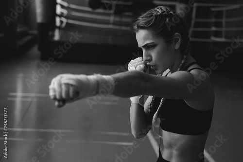 Fitness woman with the white boxing bandages. Attractive Female Boxer Training.female MMA fighter punching.