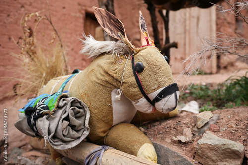 Photos Vintage toy teddy horse in Mud Clay wall background in a small rural mountain vi