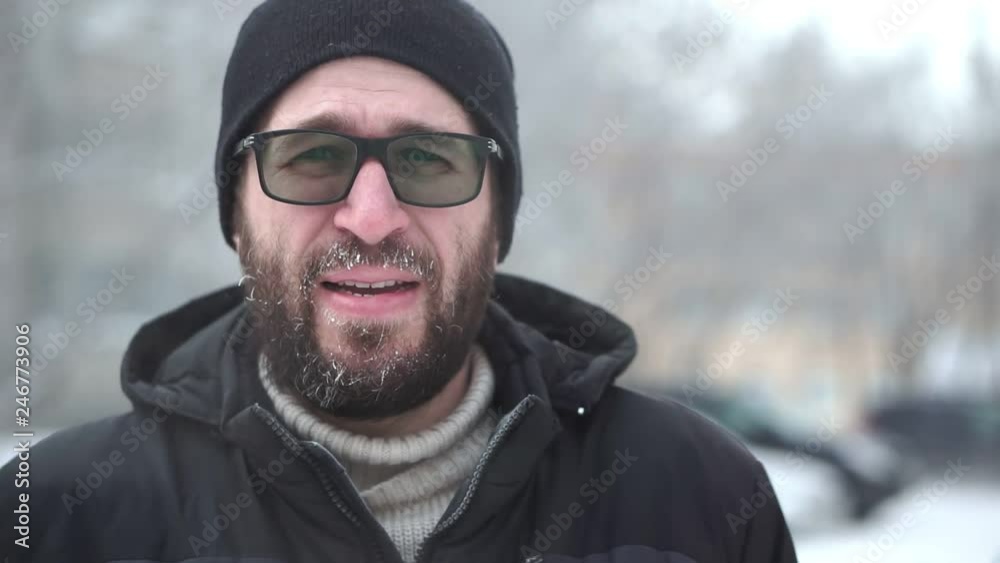 A man with a beard and glasses looks into the camera, hoarfrost. A man with a beard and glasses looks into the camera, hoarfrost.